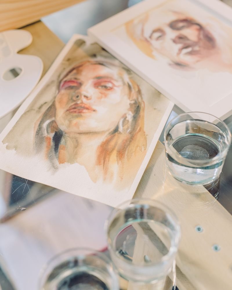 Hand-drawn portrait illustrations laid out on a studio table